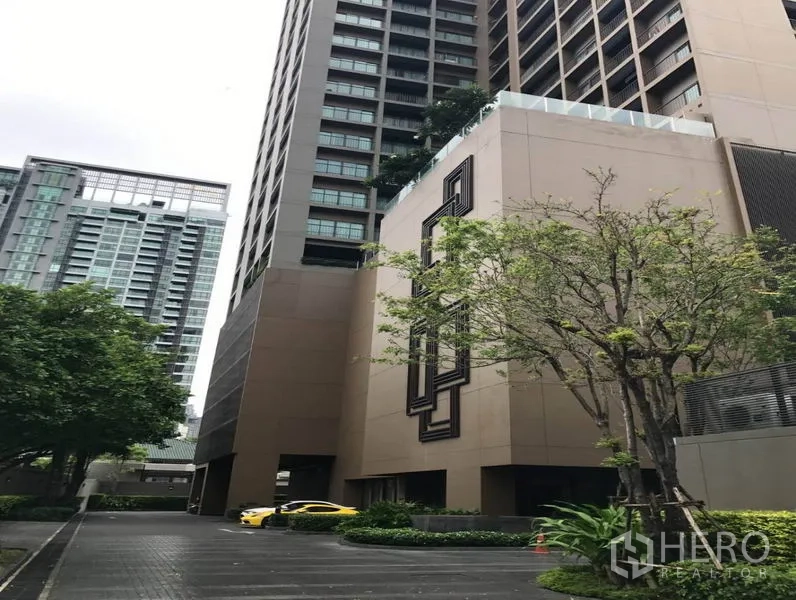 Condominium for rent in Bangkok - High-rise condominium exterior with driveway, landscaping, and surrounding towers.