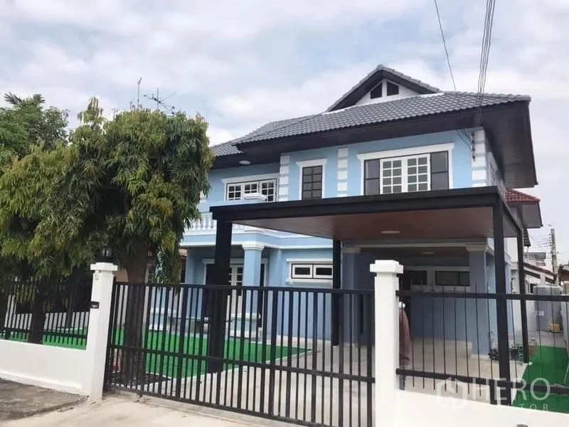 บ้าน ให้เช่าในNonthaburi - มุมมองด้านหน้าบ้านหลังรั้วเหล็กสีดำและสนามหญ้าเล็ก