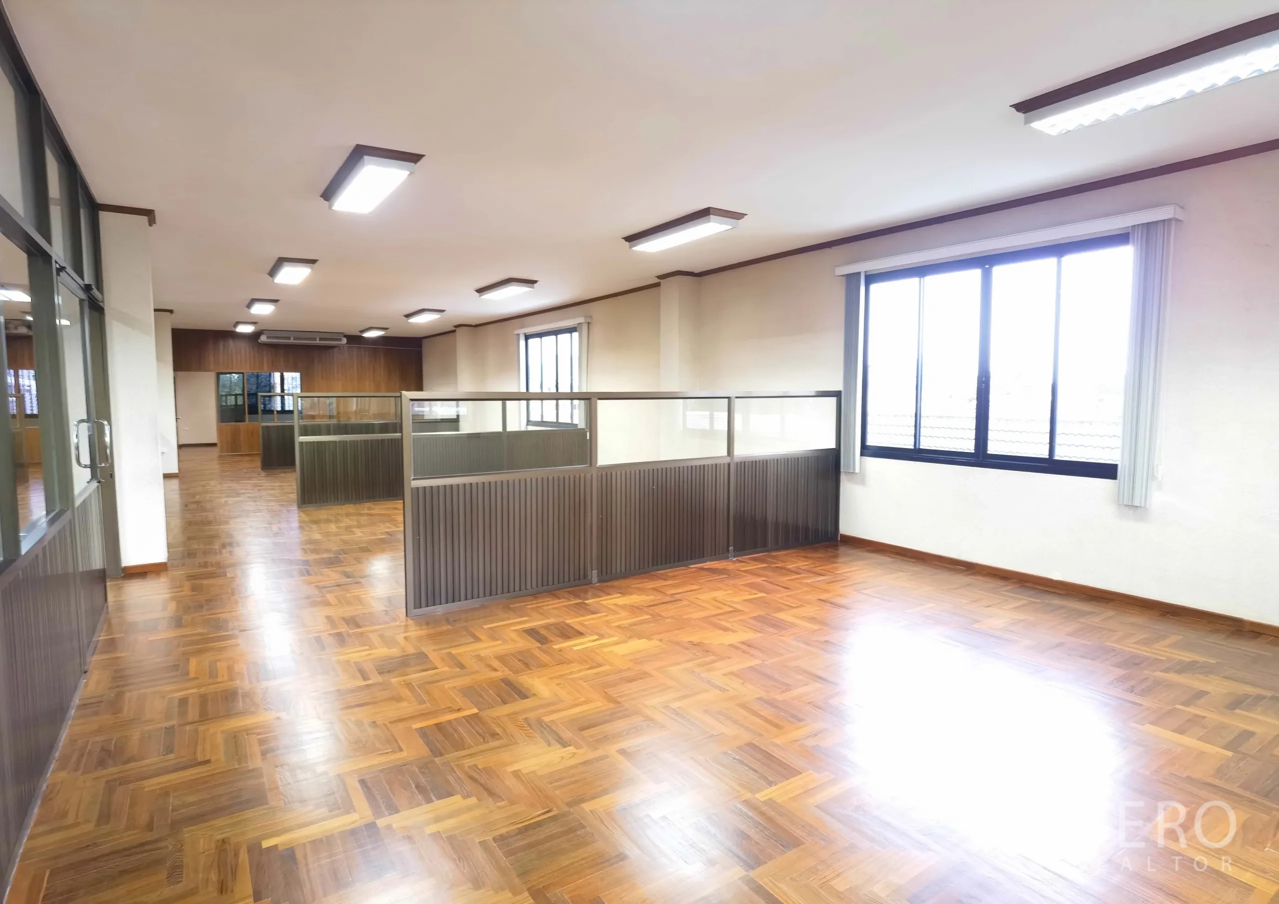 Warehouse for rent in Samut Prakan - Bright office area with cubicles, large windows and parquet floors.