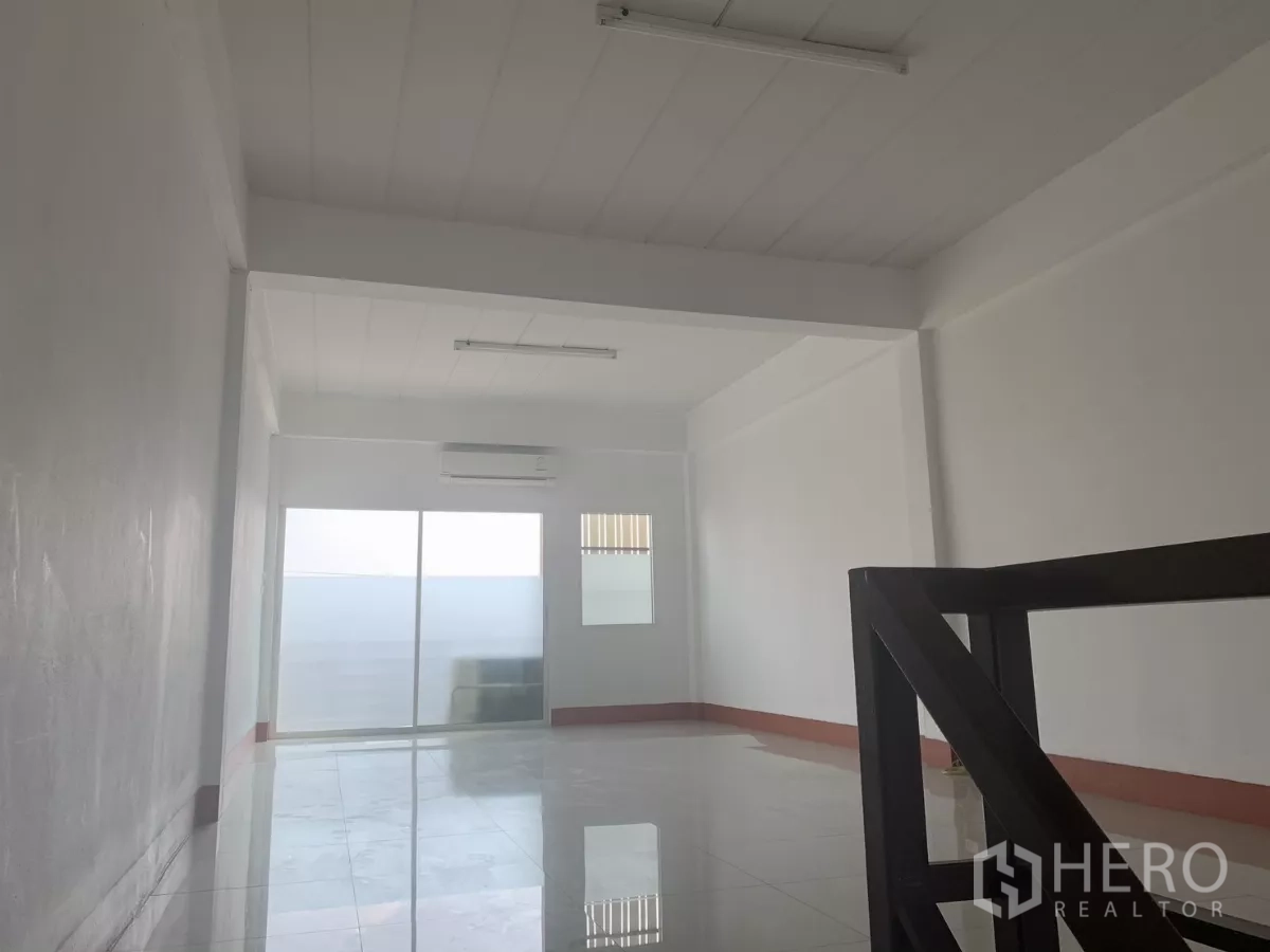 Home Office for rent in Lat Krabang, Bangkok - Open room by the stairs with AC and sliding glass doors leading to a terrace.