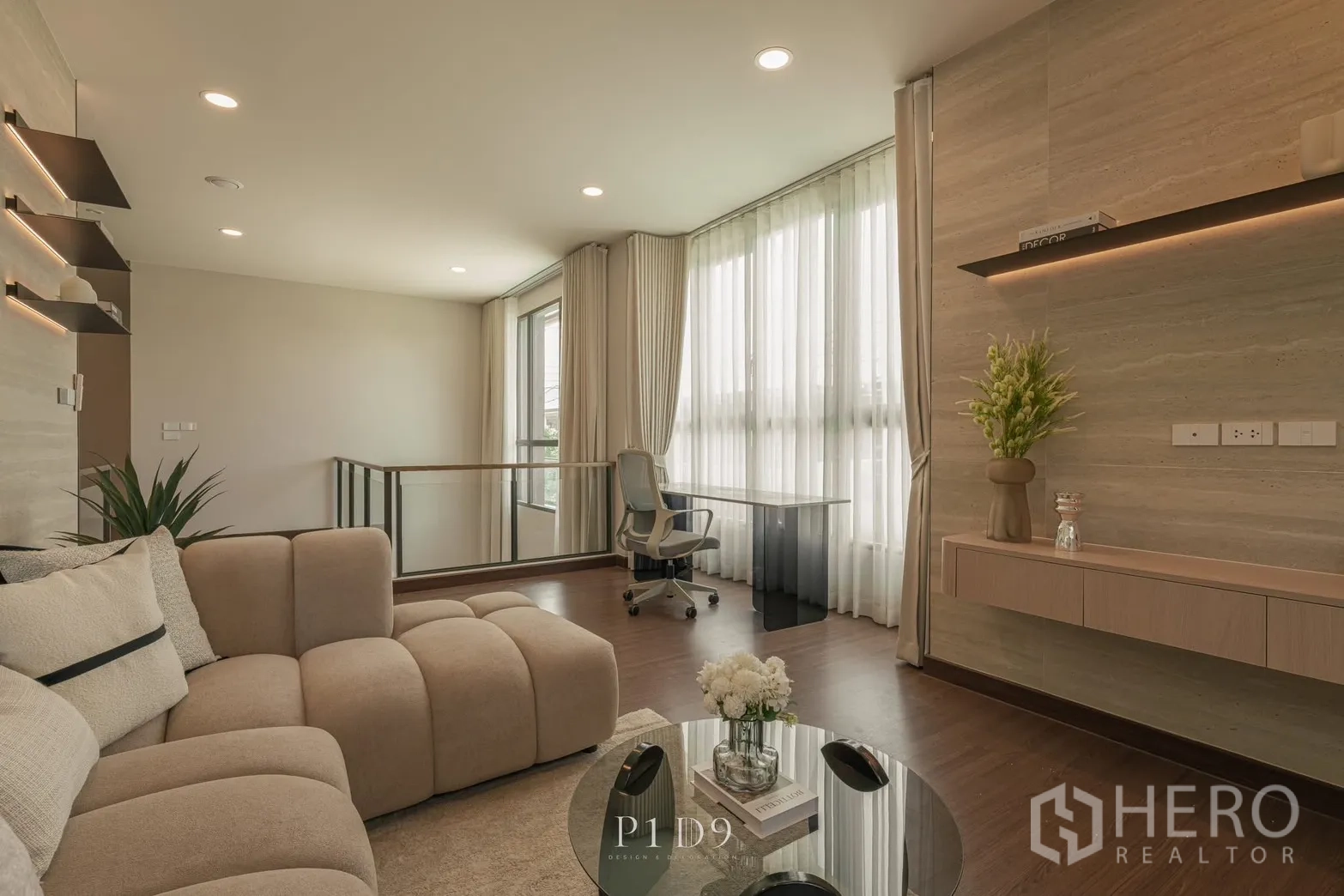 独栋房屋 for rent in Bang Phli, Samut Prakan - 休闲客厅配米色转角沙发、书桌与柔和筒灯。