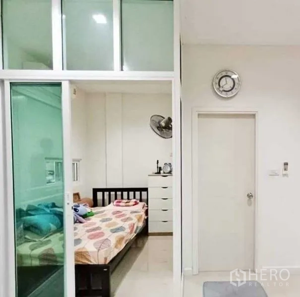 带办公室的家 出租或出售 - 小卧室位于绿色玻璃推拉门后。