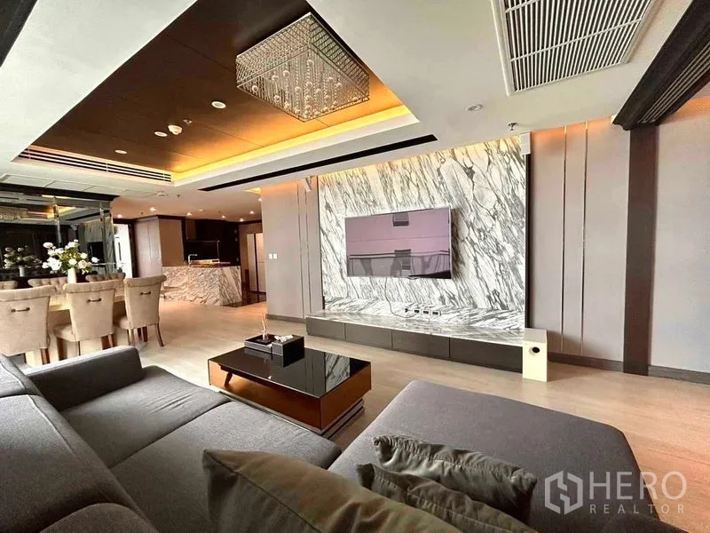 公寓 出售在Watthana, Bangkok - 豪华客厅，带大理石电视背景墙、水晶吊灯与开放式餐厨区。