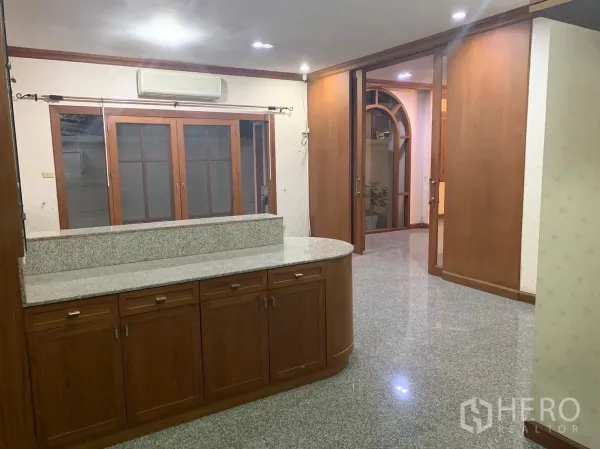 Detached House for rent in Watthana, Bangkok - Dining area with granite breakfast counter and sliding wooden doors.
