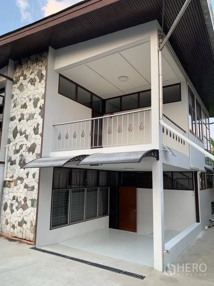 Detached House for rent in Phra Khanong, Bangkok - Exterior corner showing stone accent wall and covered balcony.
