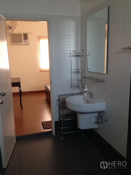 Detached House for sale in Phra Khanong, Bangkok - Neat bathroom with wall mirror, compact sink and tiled finishes.