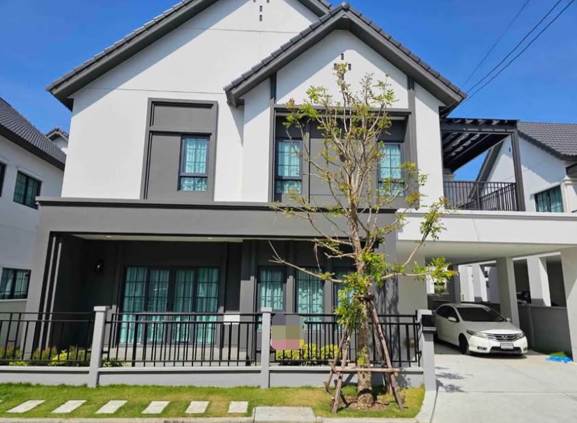บ้าน ให้เช่าในBang Phli, Samut Prakan - หน้าบ้านสไตล์โมเดิร์น 2 ชั้น รั้วสนามหญ้า และที่จอดรถมีหลังคา ใต้ท้องฟ้าแจ่มใส