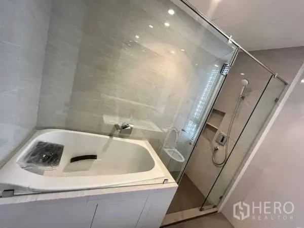 公寓 出租或出售在Watthana, Bangkok - 现代浴室，玻璃隔间内设浴缸与步入式淋浴，位于Ekkamai公寓