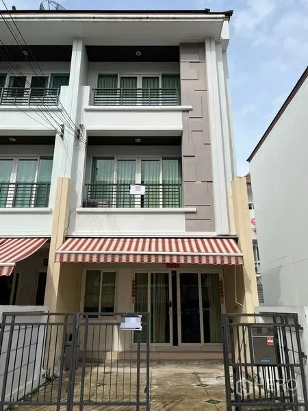 Townhouse for rent in Wang Thonglang, Bangkok - Three-storey modern townhouse facade with gated parking and striped awning