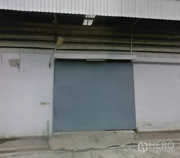 货栈 出租在Bang Phli, Samut Prakan - 邦披工业仓库外立面，配大尺寸钢制推拉门、金属屋顶与混凝土装卸坡道。