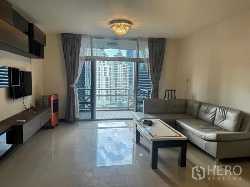 公寓 出租在Pathum Wan, Bangkok - 客厅配L型沙发与茶几，阳台框出城市景观。