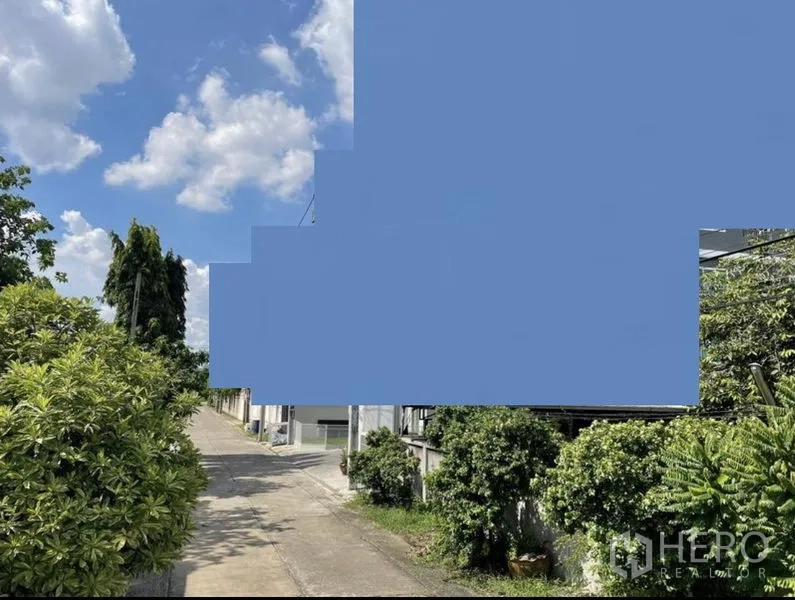 Land for sale in Suan Luang, Bangkok - Quiet concrete alley access lined with trees and low-rise homes leading to the plot.