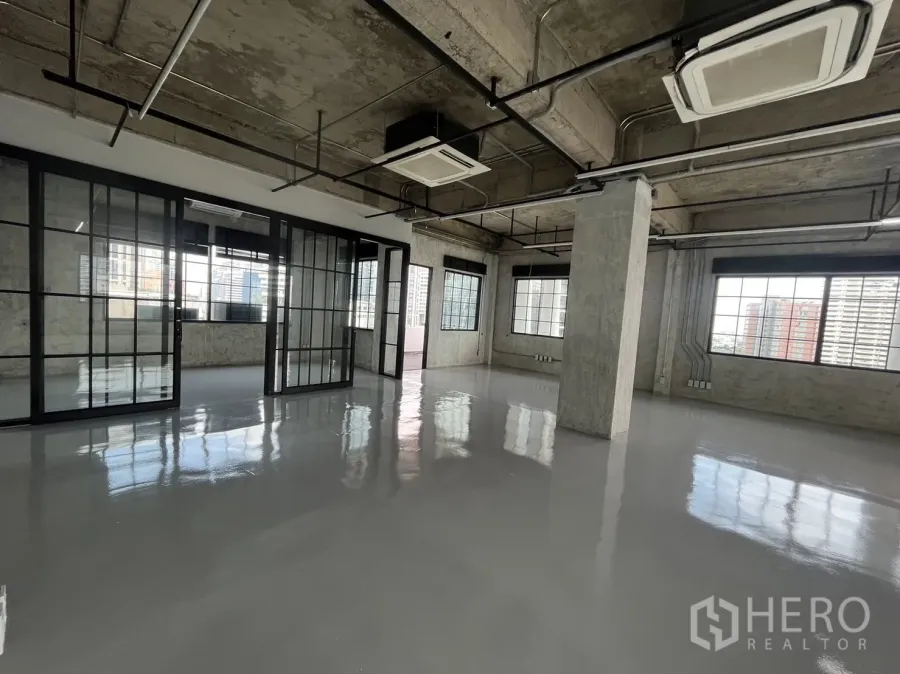 办公空间 出租在Khlong Toei, Bangkok - 空置Loft风办公室，亮面地坪、黑框玻璃隔断与裸露天花，城市景观窗。