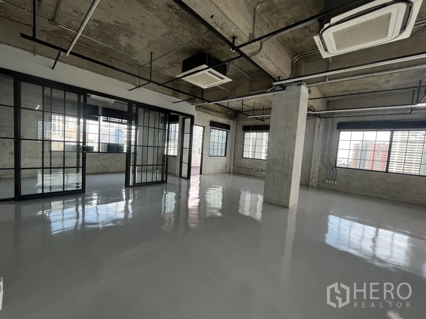 办公空间 出租在Khlong Toei, Bangkok - 空置Loft风办公室，亮面地坪、黑框玻璃隔断与裸露天花，城市景观窗。