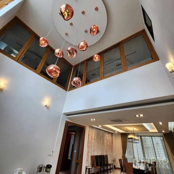 独立式住宅 出售在Phra Khanong, Bangkok - 挑高门厅，点缀铜色吊灯与上层窗户