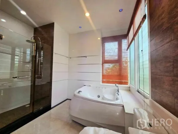 Detached House for rent in Chatuchak, Bangkok - Spa-style bathroom featuring a jacuzzi tub beside tall windows and a glass walk-in shower.
