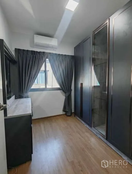 Townhouse for rent in Bang Phli, Samut Prakan - Compact bedroom with wood floor, window with dark curtains, built-in glass wardrobe and air conditioner.
