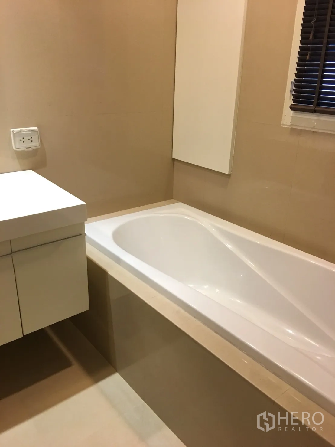 Condominium for rent in Watthana, Bangkok - Second bathroom with soaking bathtub, wall cabinet and window blinds.