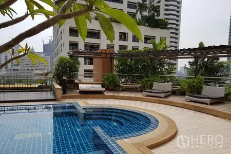 公寓 出租在Watthana, Bangkok - 屋顶泳池，设日光躺椅、花架与绿植，俯瞰城市大楼。