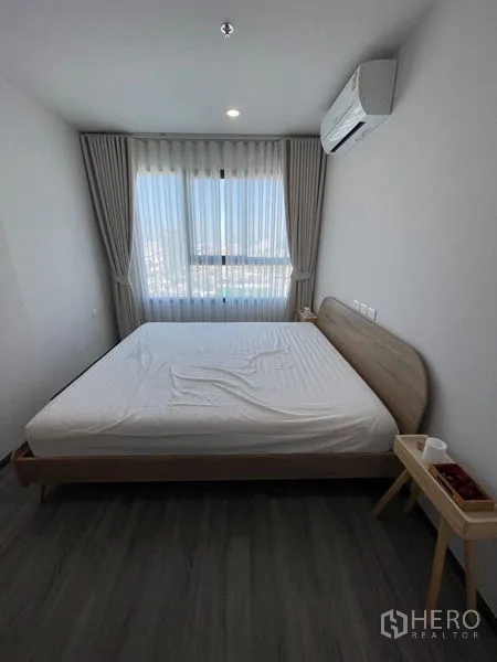 Condominium for rent - Master bedroom with large window, air-conditioning and double bed over wood flooring.