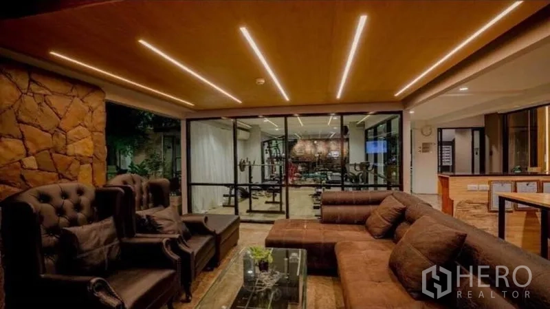 Retail Space for sale in Phra Nakhon, Bangkok - Cozy lounge with leather sofas facing a glass-walled fitness gym and a bar counter.