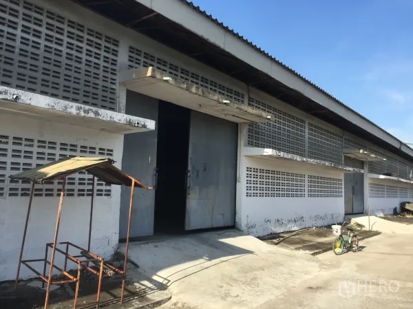 คลังสินค้า ให้เช่าในMin Buri, Bangkok - ด้านหน้าโกดัง มีทางลาดขนถ่ายสินค้า ประตูเหล็ก และผนังบล็อกช่องลม