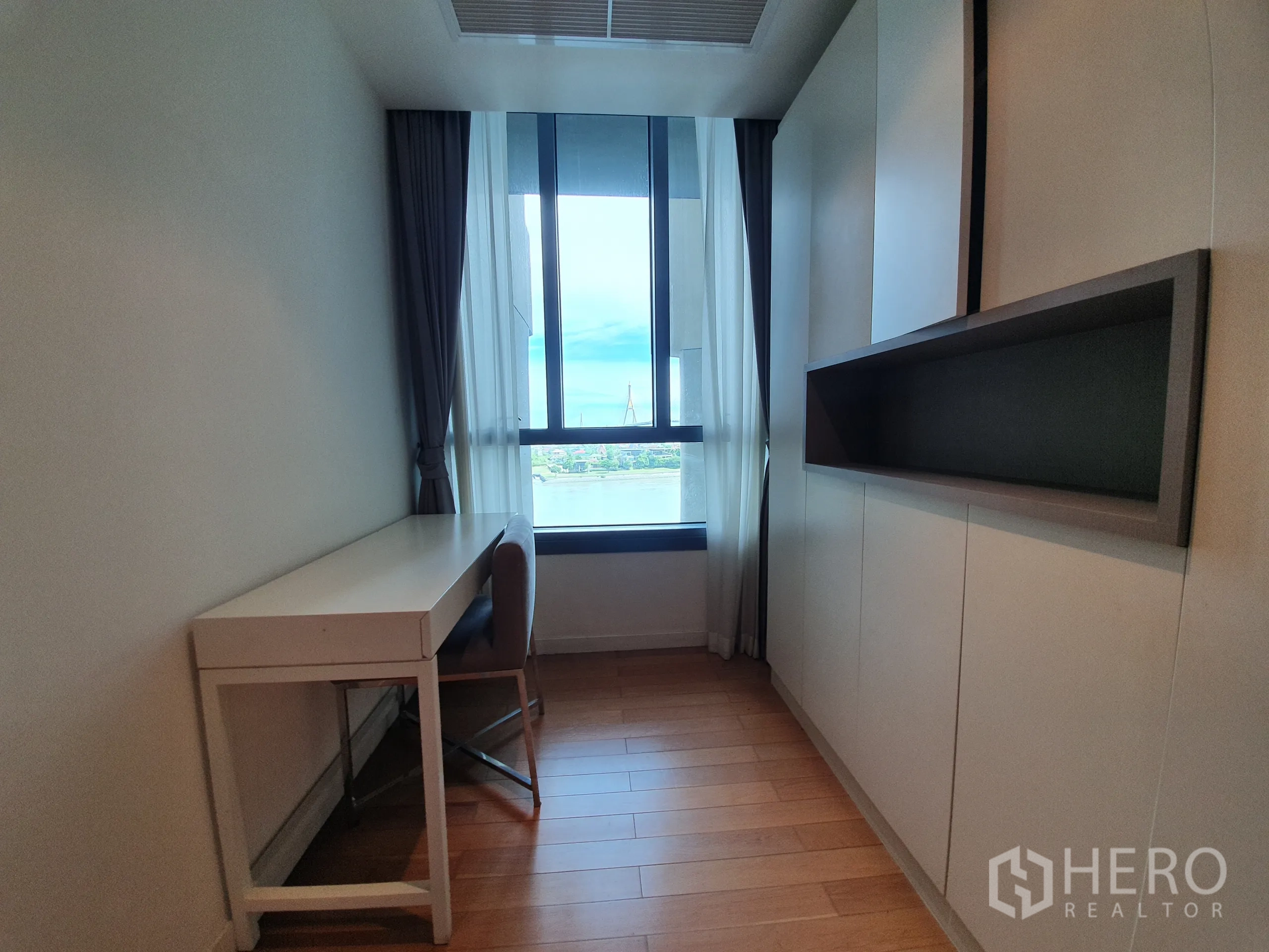 公寓 出租或出售在Yan Nawa, Bangkok - 紧凑书房，窗边书桌与柜体，可观河景。