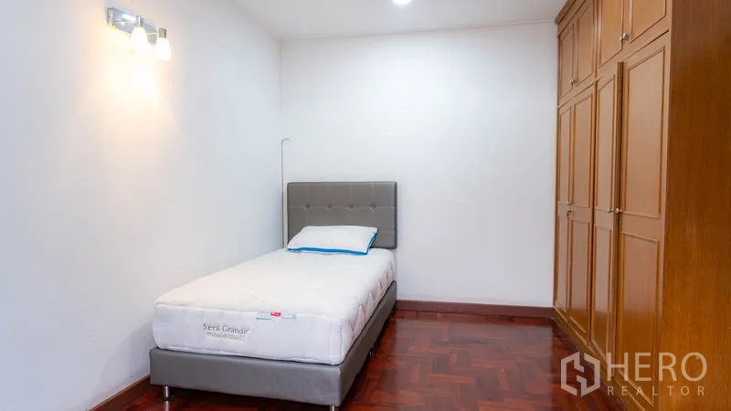 Townhouse for rent in Watthana, Bangkok - Bedroom with a single bed and built‑in wooden wardrobe.