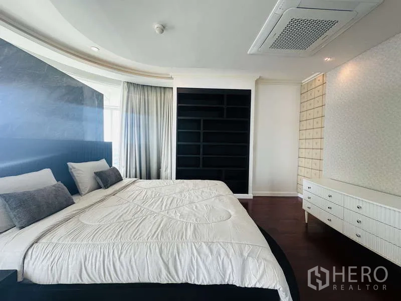 Condominium for rent or sale in Khlong Toei, Bangkok - Close view of master sleeping area with padded headboard, black built-in shelves and curtain wall.