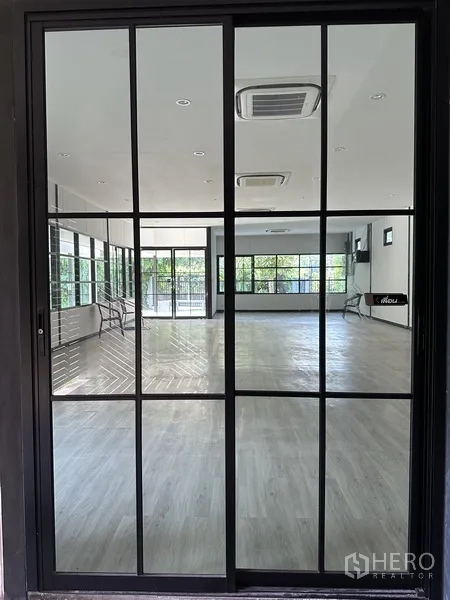 独立式住宅 出租在Khlong Toei, Bangkok - 黑框玻璃推门，映出明亮的工作室与浅色地板