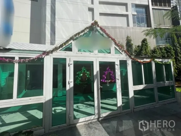 零售空间 出租在Watthana, Bangkok - 城市庭院中的玻璃门面铺面，绿色隔热玻璃与装饰彩带