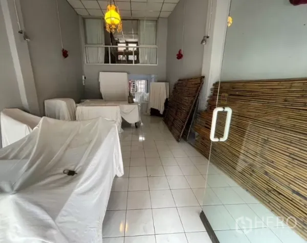 店屋 出租在Watthana, Bangkok - 店内向后方延伸，带夹层窗与玻璃门，一侧堆放竹制隔板。