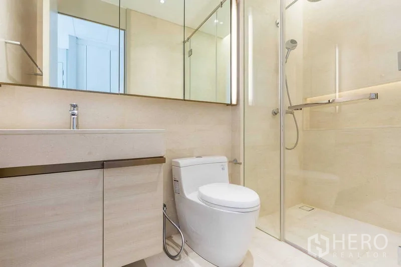 Condominium for sale in Pathum Wan, Bangkok - Another angle of the open-plan living room with large sofa and ambient lighting