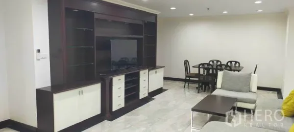 Condominium for rent in Watthana, Bangkok - Large entertainment wall with TV facing an open-plan dining area.