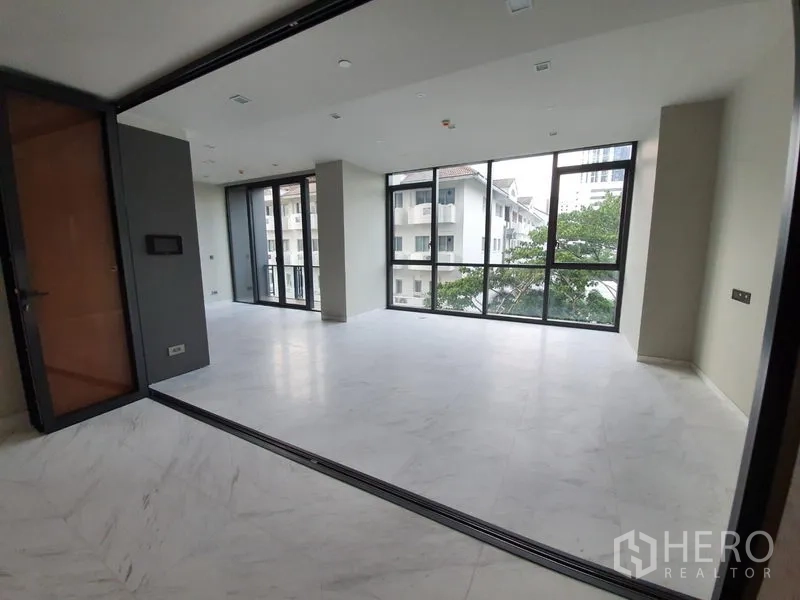 คอนโด ให้เช่าในWatthana, Bangkok - ห้องนั่งเล่นโปร่งโล่ง กระจกเต็มบานมุมห้อง พื้นลายหินอ่อน ในคอนโดทองหล่อ
