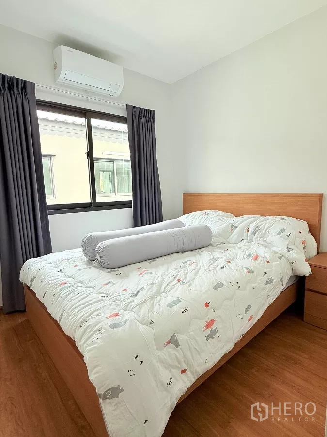 Townhouse for rent in Bang Phli, Samut Prakan - Cozy bedroom with double bed, bedside table, and window with blackout curtains.