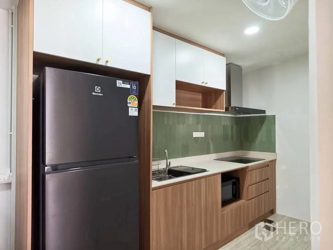 ทาวน์เฮาส์ for rent in Bang Phli, Samut Prakan - ครัวสไตล์โมเดิร์นพร้อมตู้เย็นสองประตู ผนังกันเปื้อนกระเบื้องสีเขียว เตาไฟฟ้า และตู้บิลท์อินไม้