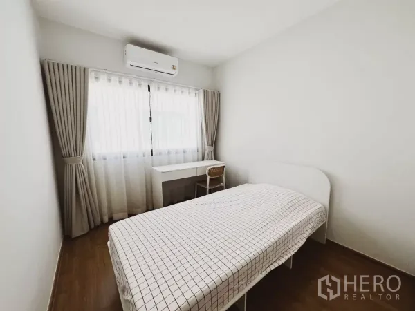 ทาวน์เฮาส์ ให้เช่าในBang Phli, Samut Prakan - ห้องนอนเล็กเตียงเดี่ยว โต๊ะทำงาน และเครื่องปรับอากาศข้างหน้าต่างม่านทึบโปร่ง