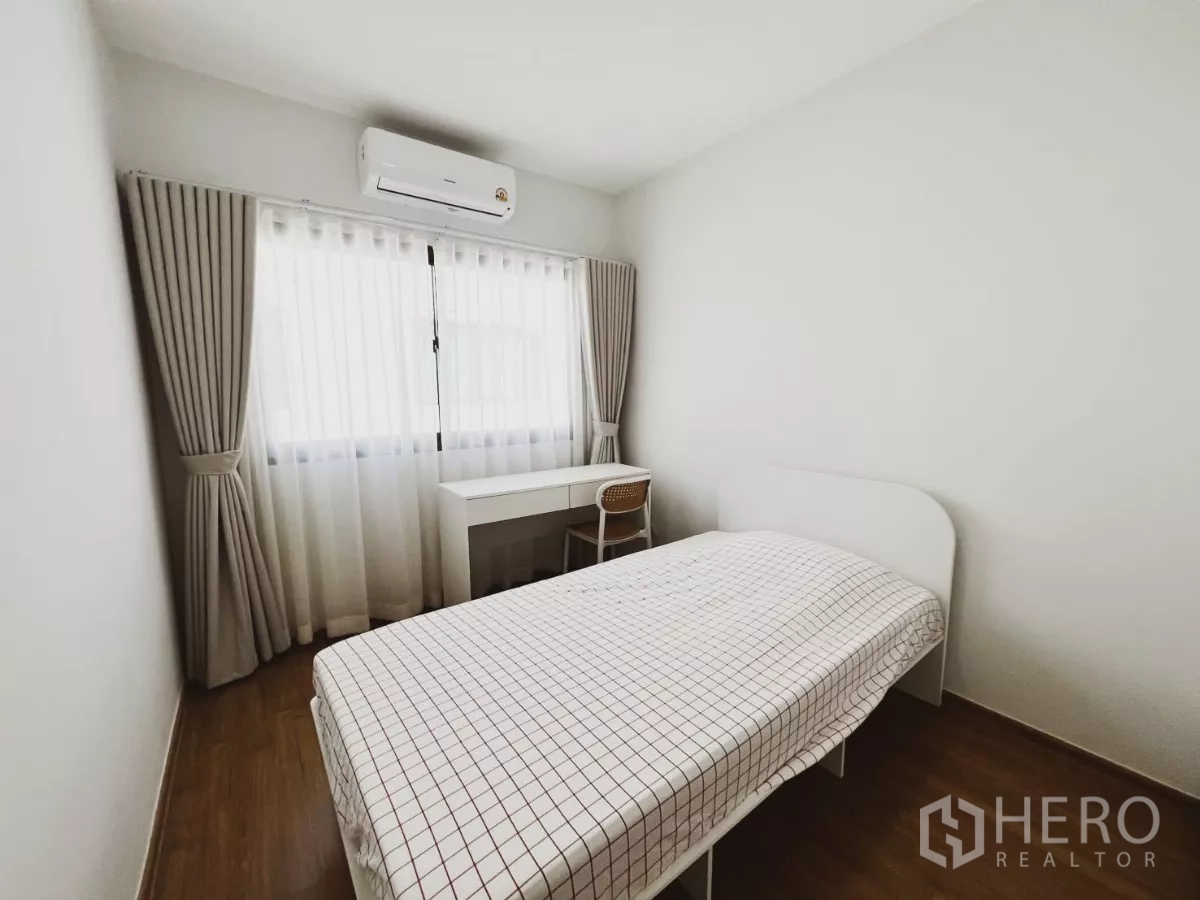 ทาวน์เฮาส์ ให้เช่าในBang Phli, Samut Prakan - ห้องนอนเล็กเตียงเดี่ยว โต๊ะทำงาน และเครื่องปรับอากาศข้างหน้าต่างม่านทึบโปร่ง