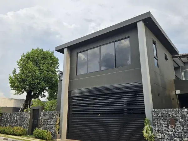 独立式住宅 出售在Thawi Watthana, Bangkok - 特写黑色卷帘车库门及二楼窗户。