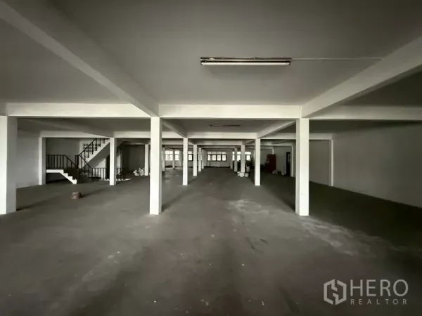 Shophouse for rent - Large upper-floor open area with columns and a side staircase.
