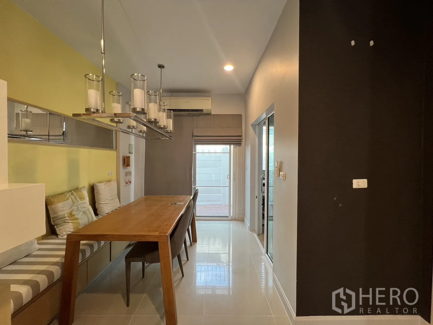 联排别墅 出租在Wang Thonglang, Bangkok - 餐区配长木桌、卡座与吊灯。