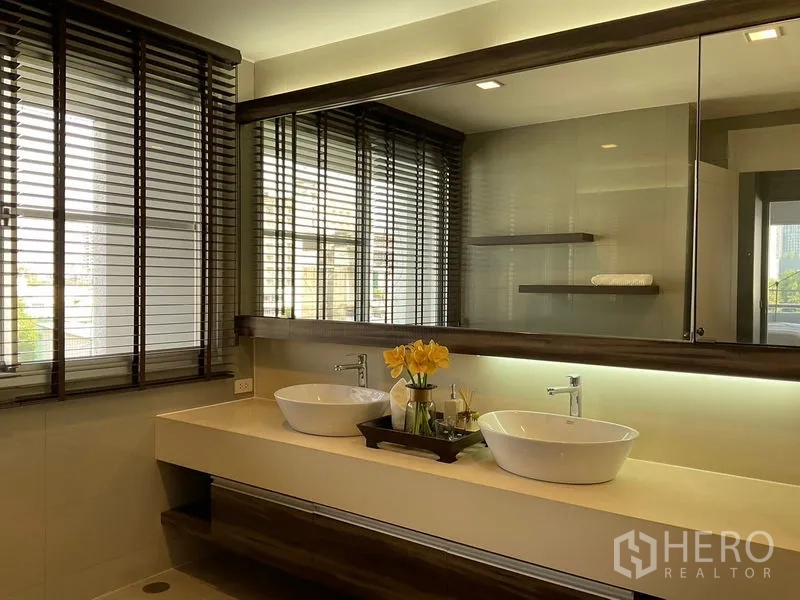 Apartment for rent in Sathon, Bangkok - Double vanity bathroom with large mirror and vessel sinks.
