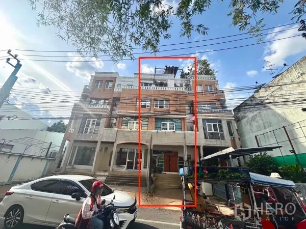 Shophouse for rent in Watthana, Bangkok - Four-storey shophouse facade in Watthana with the offered unit outlined and active street frontage.
