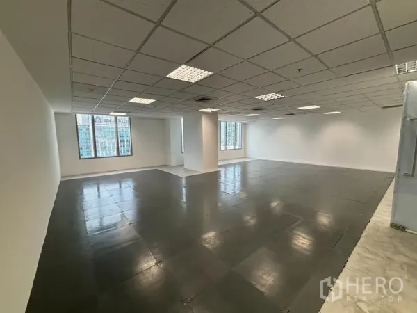 Office Space for rent in Watthana, Bangkok - Wide view of empty floor plate with columns, reflective tiled floor, and multiple windows bringing natural daylight.