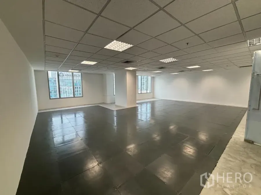 Office Space for rent in Watthana, Bangkok - Wide view of empty floor plate with columns, reflective tiled floor, and multiple windows bringing natural daylight.