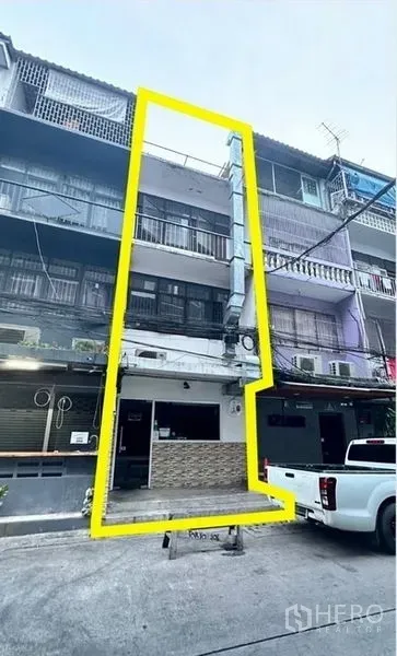 店屋 出租或出售 - 用黄色边框标示物业范围的建筑外观，安静小巷与停放的皮卡。