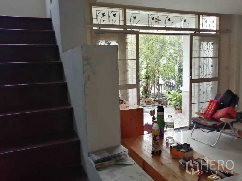 独立式住宅 出售在Prawet, Bangkok - 楼梯通向带花纹铁艺的玻璃门，通往露台。