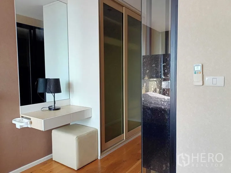 公寓 出租在Watthana, Bangkok - 卧室一角设梳妆台、全身镜、软墩与推拉衣柜门。