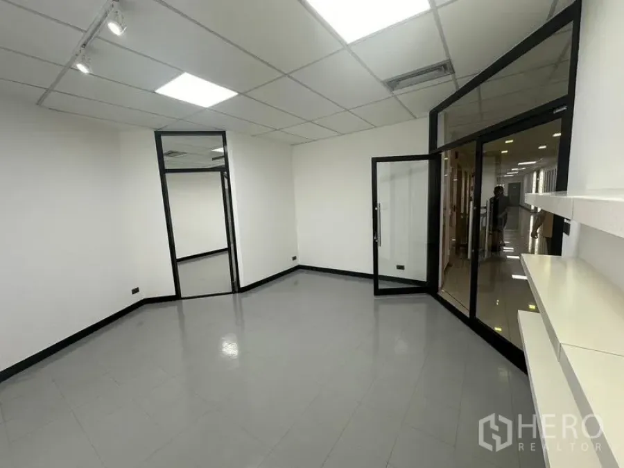 Office Space for rent - Entry area with shelving and glass doors opening to the corridor of the office floor.
